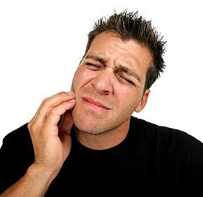 Man holding his jaw in pain in need of some sedation dental care